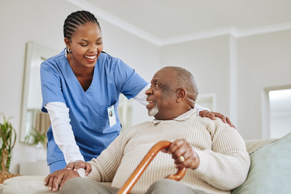 A female caregiver talks to a senior man in his home at a part of our private duty home care in Michigan