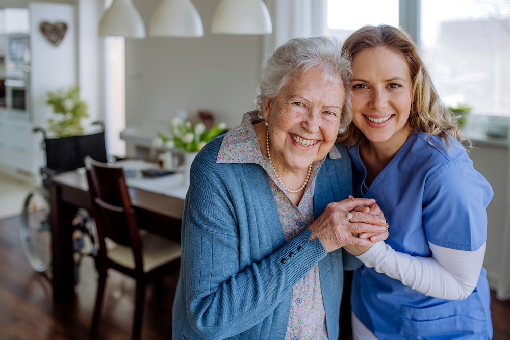 A senior woman hugs her caregiver who works for our private duty home care in Michigan