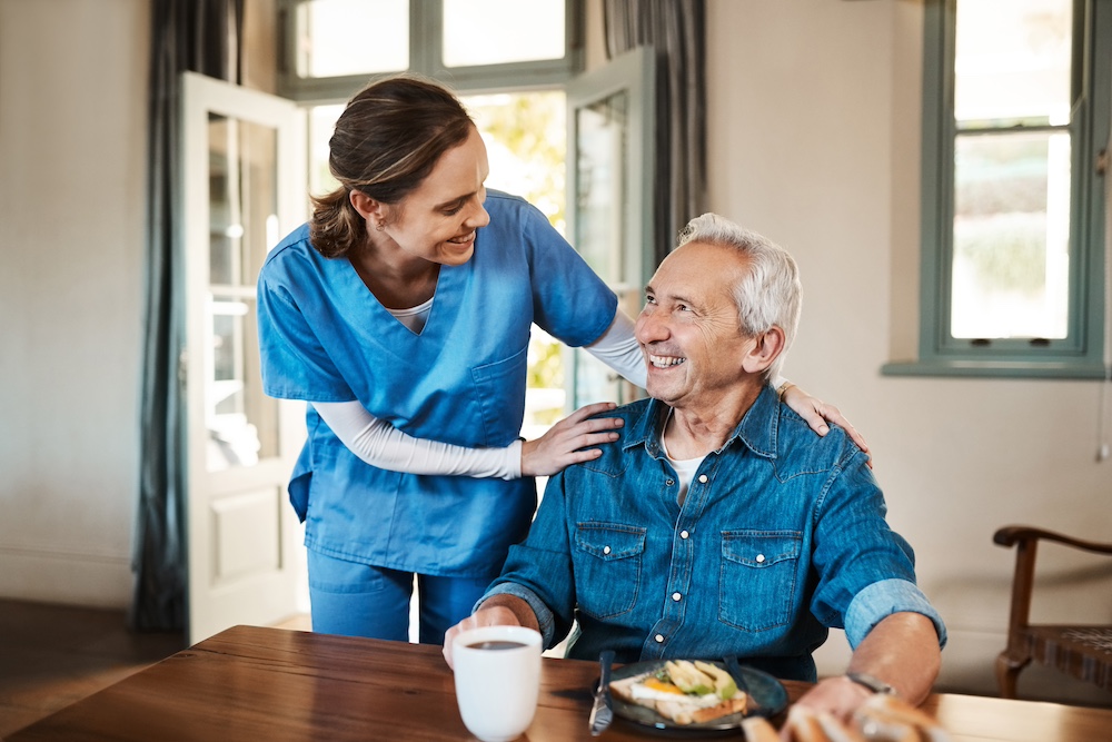 A caregiver serving a senior man a health breakfast as a part of the many care options available from home health care services in Michigan