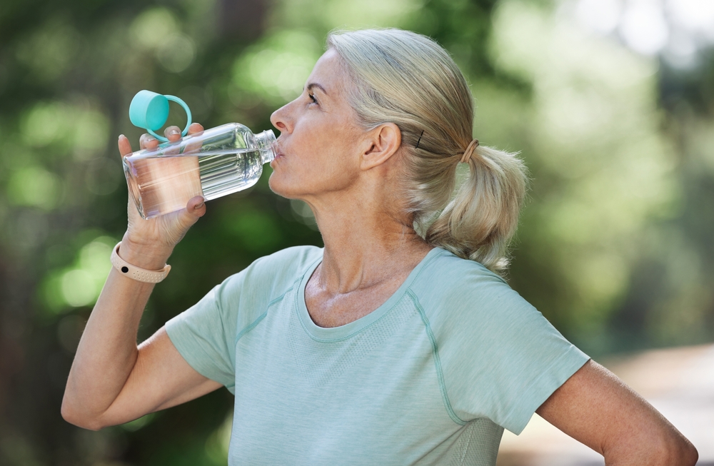 Woman drinking water in senior care management in Michigan.