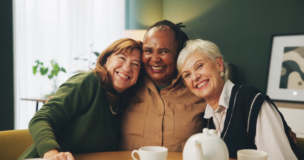 Senior women friends hugging and enjoying senior living